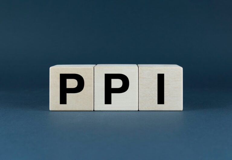 Three wooden cubes on a navy blue background, each emblazoned with a letter to spell ‘PPI’.