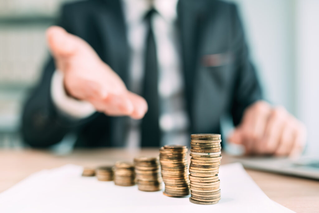 A close-up of a person in an office with stacked coins in front of them.
